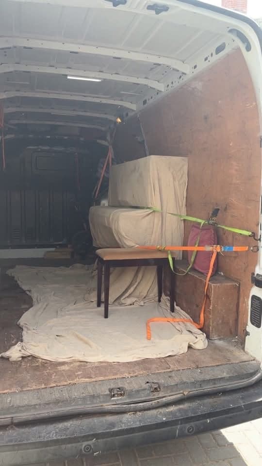Inside a van: furniture wrapped in dust sheets and strapped down for a move